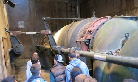 Schülergruppe der Jahrgangsstufe 1 des Technischen Gymnasiums Schwenningen vor einer alten Wasserturbine im Kraftwerk Wyhlen-Augst